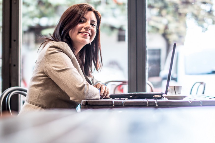 a picture of the author sitting at a table with a laptop.